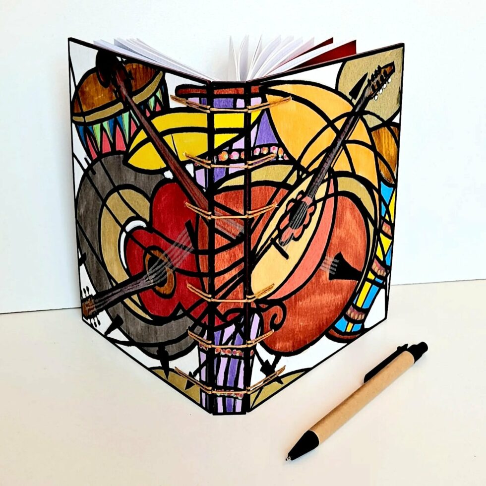 Carnet COSMA, couverture ouverte en éventail et reliure cousue.