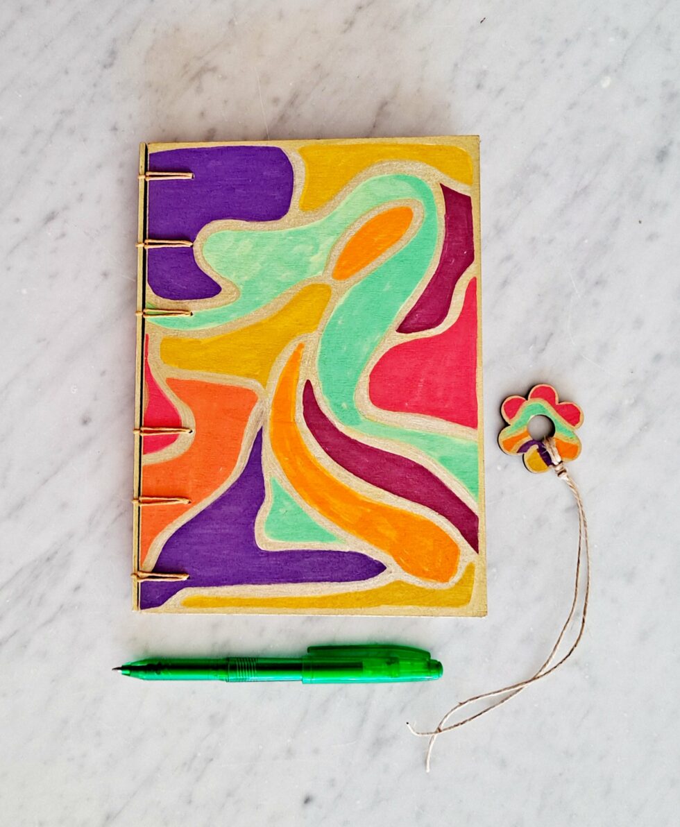 Carnet NÄSS face avec stylo vert et marque page en bois.