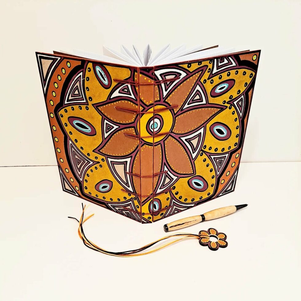 Carnet CANNELLE vue debout ouvert avec marque page fleur en bois.