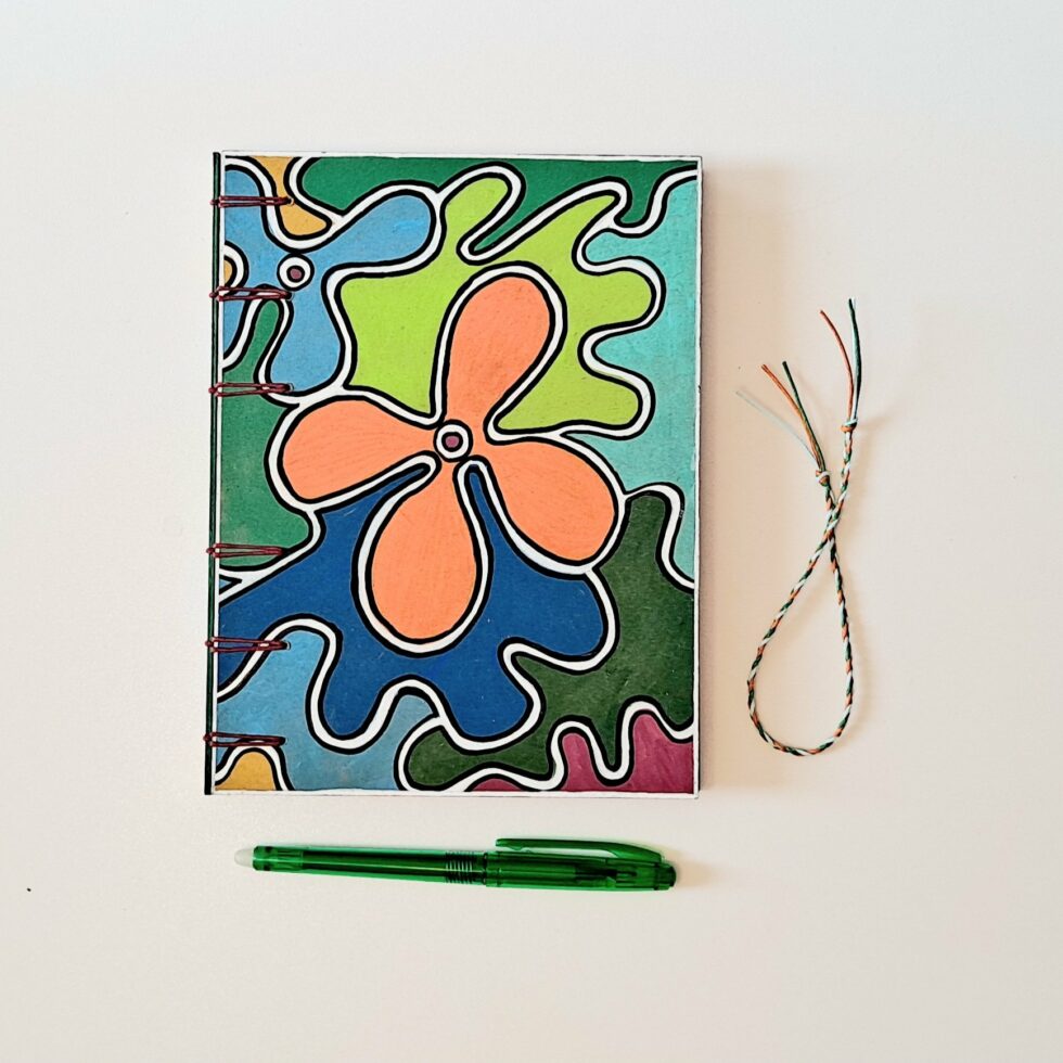 Carnet CAPUCINE, vue recto de face avec stylo vert et marque page en fil.