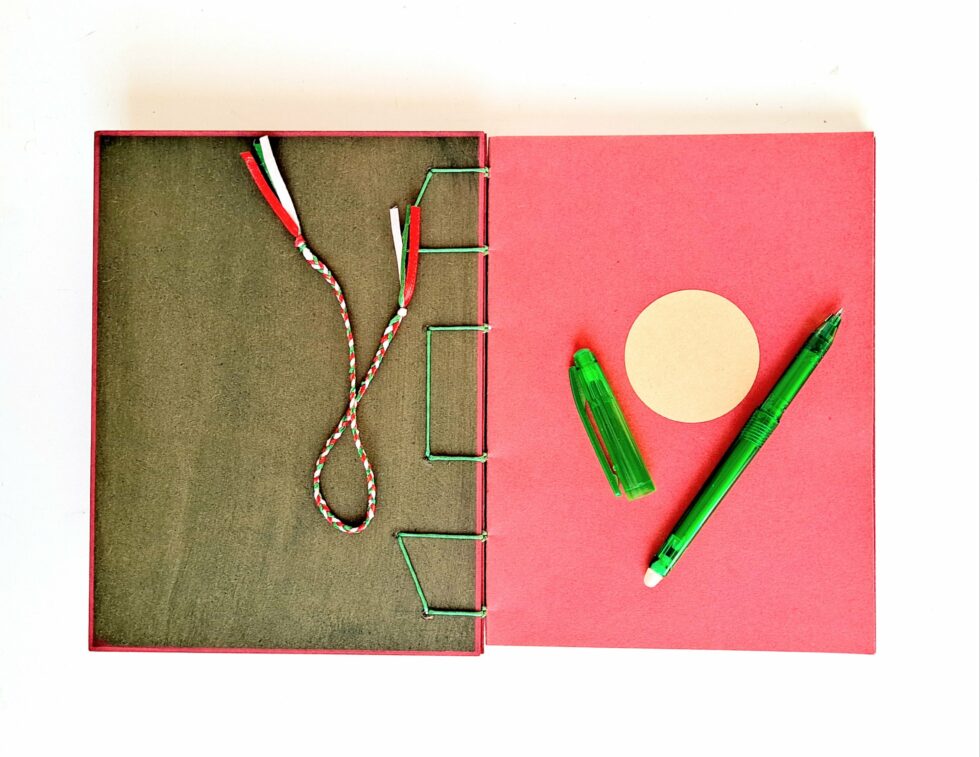 Carnet SOLINE vue intérieure couverture et page de garde avec reliure verte, marque pages et stylo vert.