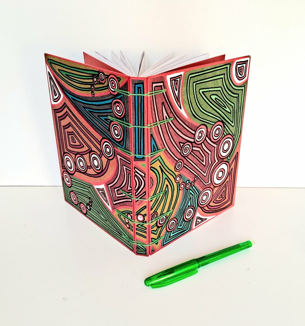 Carnet SOLINE vue recto verso debout avec reliure verte et stylo vert.