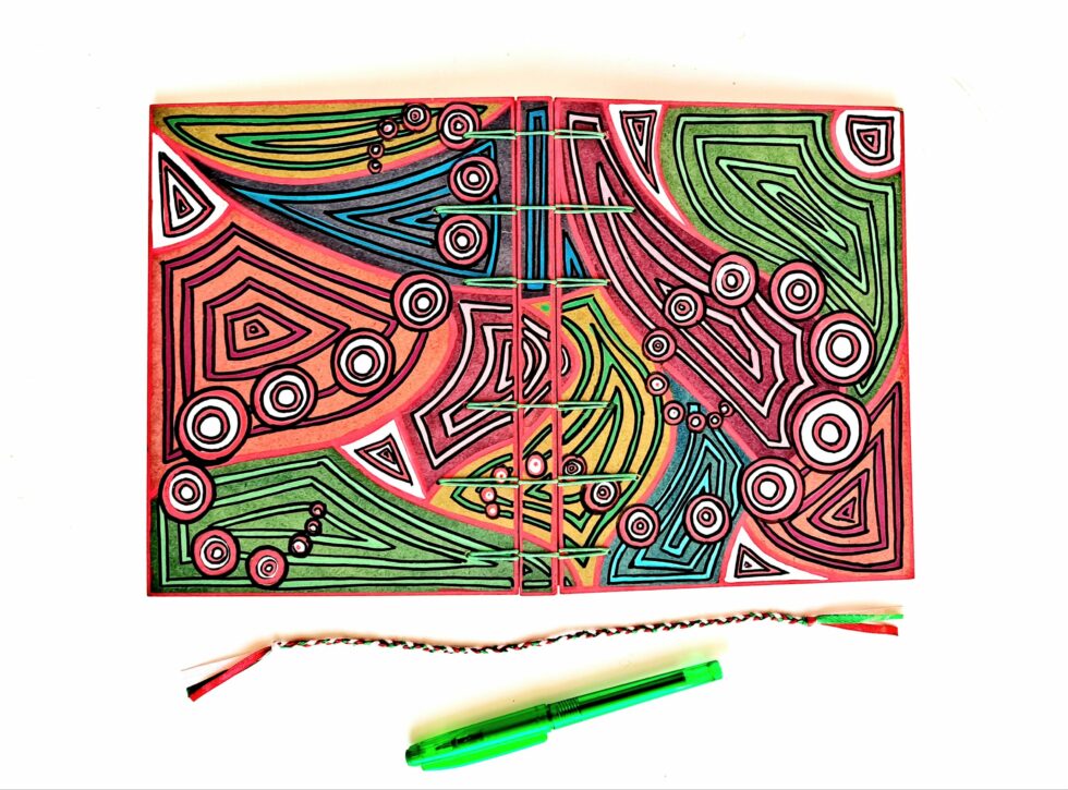 Carnet SOLINE vue recto verso à plat avec reliure verte, marque pages et stylo vert.