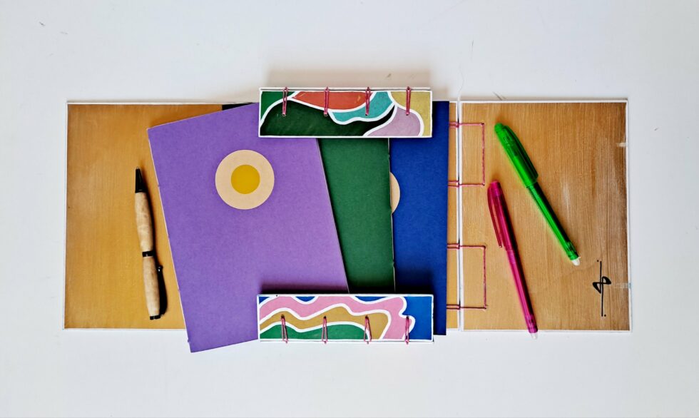 Boîte à mots CHARLIE vue 2 pans ouverts avec carnets et stylo en bois.