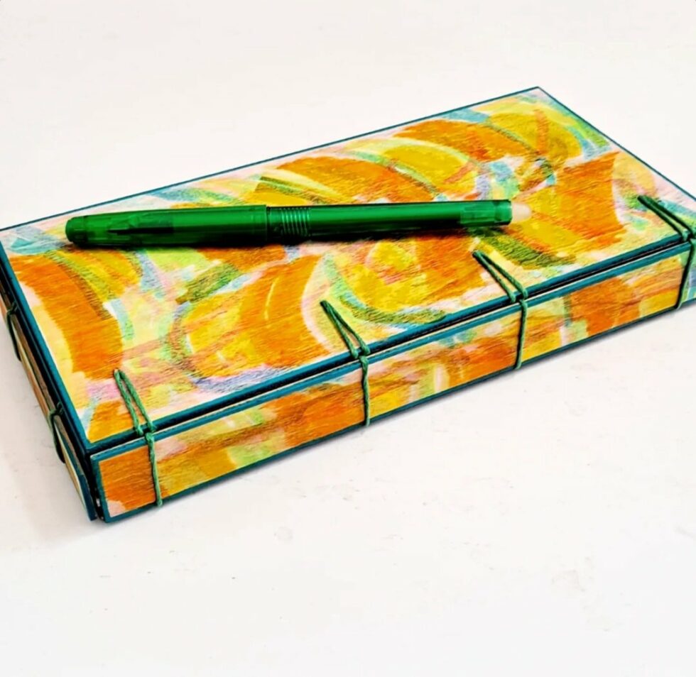 Boîte à mots AGATHE vue fermée recto avec dos reliure verte et stylo vert.