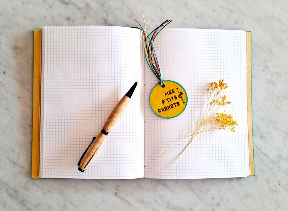 Carnet JELLY vue intérieure sur pages avec fil turquoise et marque-pages en bois et stylo en bois.
