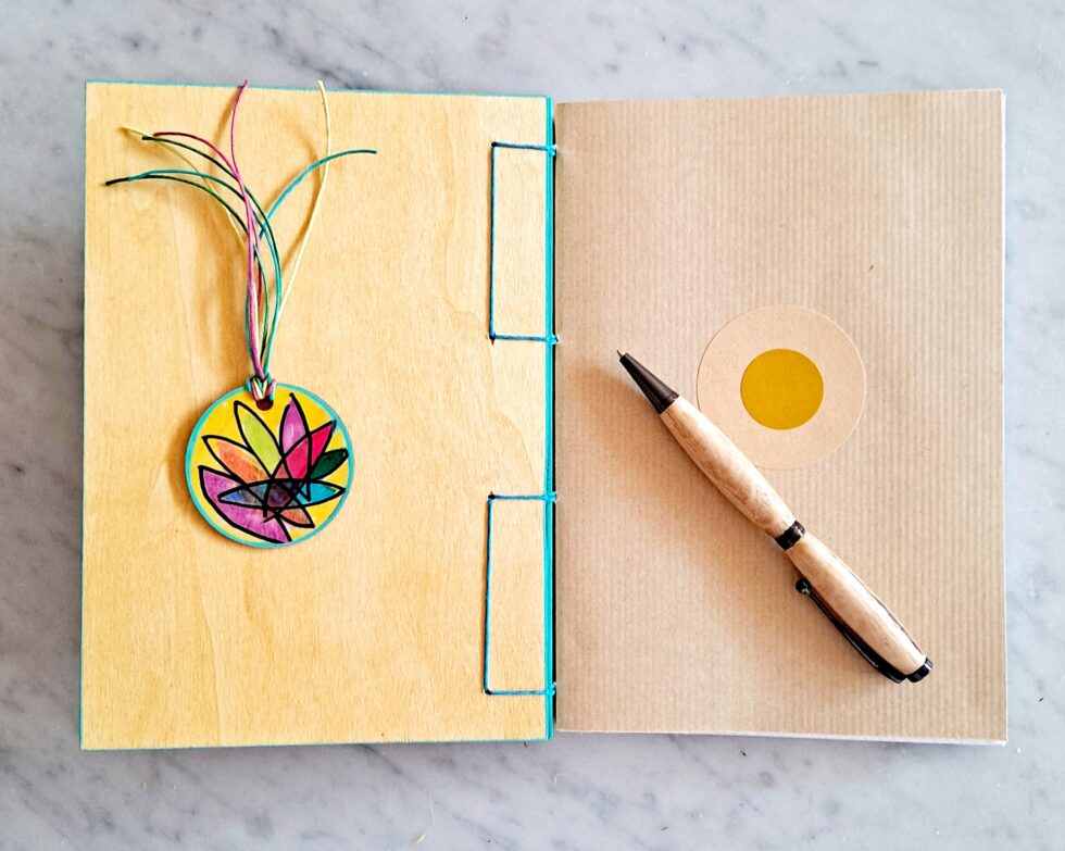 Carnet JELLY vue intérieure sur pages et couverture avec fil turquoise et marque-pages en bois et stylo en bois.