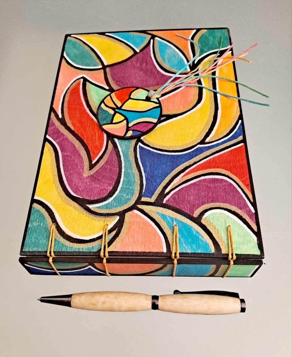 Album DISCO vue recto à plat avec dos reliure avec stylo en bois et marque pages en bois peint.