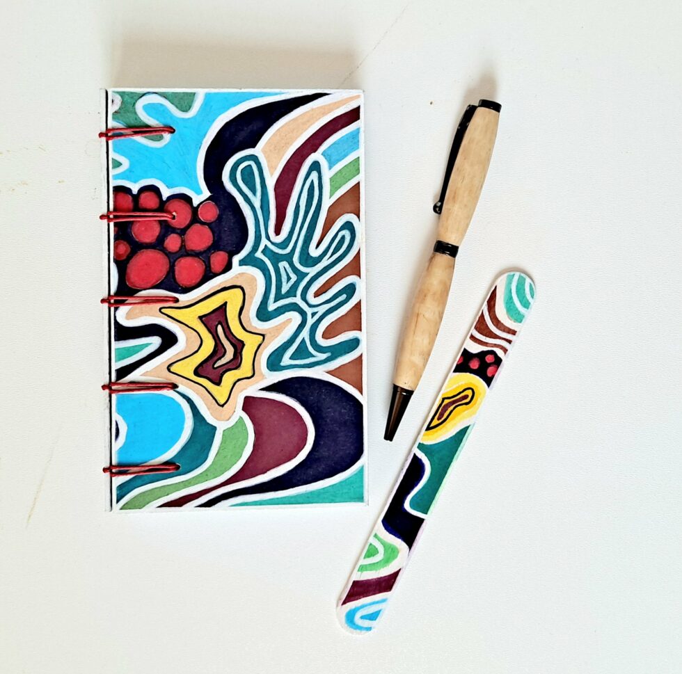 Carnet ATOCA vue recto à plat avec stylo en bois et marque pages en bois peint.