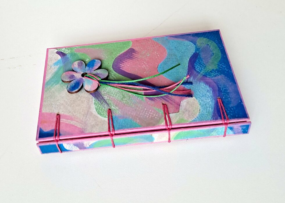 Carnet PASTEL vue recto et dos reliure rose avec marque pages en bois peint.