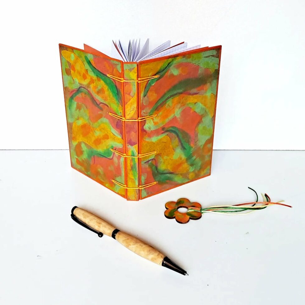 Carnet VENCE vue recto verso debout avec son marque-pages fleur bois peint et stylo en bois.