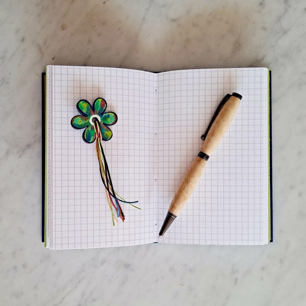 Carnet GENTIANE vue intérieure sur pages avec reliure fil jaune et marque-pages fleur et stylo en bois