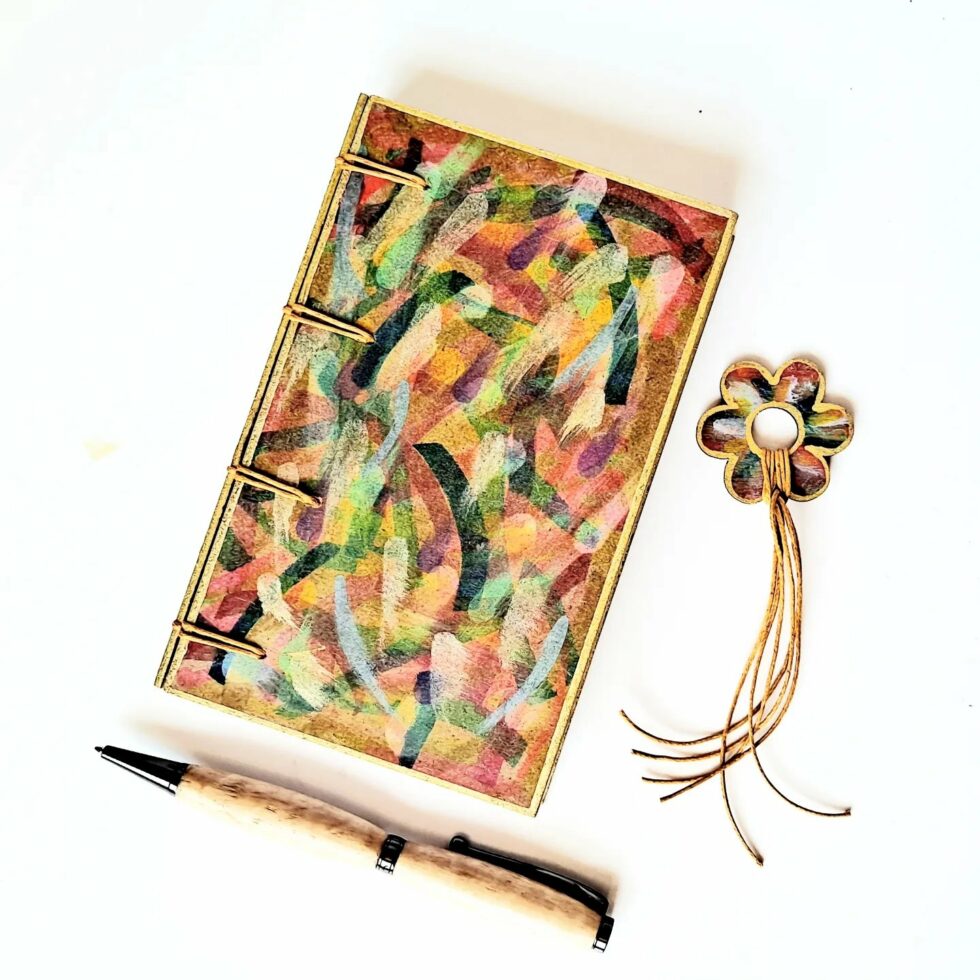 Carnet FIDJI vue recto à plat avec marque-pages fleur et stylo en bois.