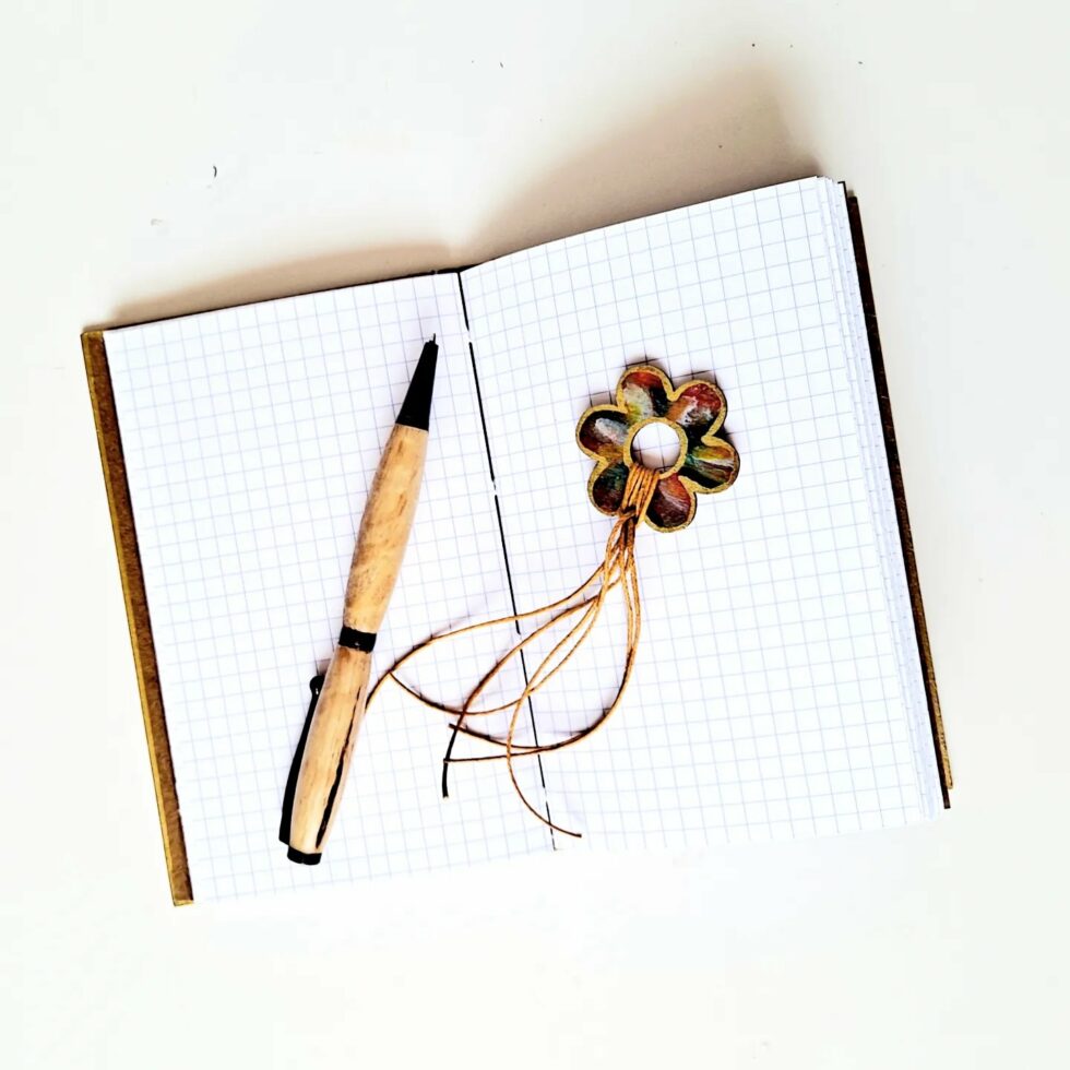 Carnet FIDJI vue intérieure recto verso à plat avec marque-pages fleur et stylo en bois.