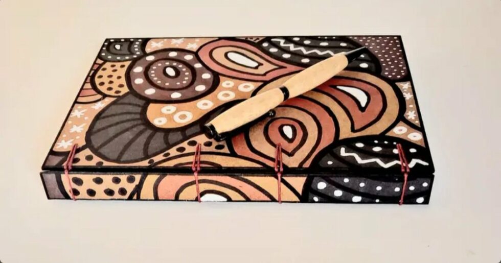 Carnet CARAMEL vue recto sur dos avec marque-pages et stylo en bois.