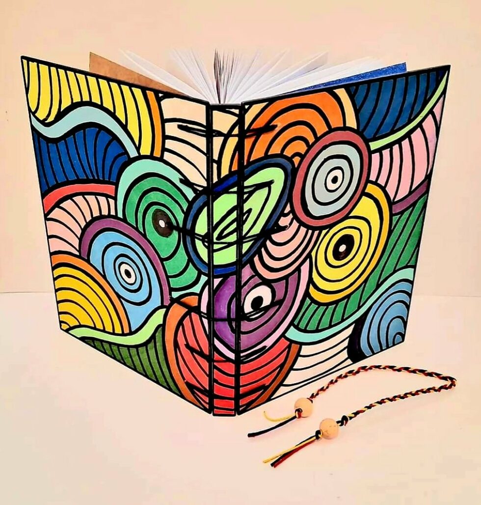 Notebook KALÉIDOSCOPE vue recto verso debout avec marque-pages en fil de reliure.