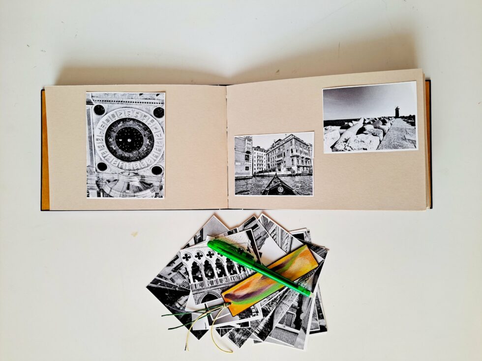 Album MAHÉ, vue intérieure sur pages avec marque-pages en bois peint et stylo vert.