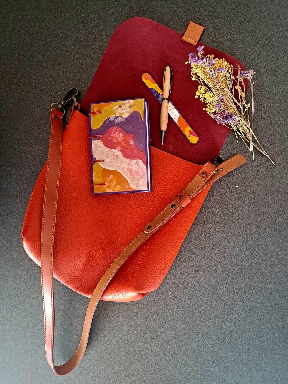 Carnet PASTORAL vue recto sur sac avec stylo en bois et marque page en bois peint.