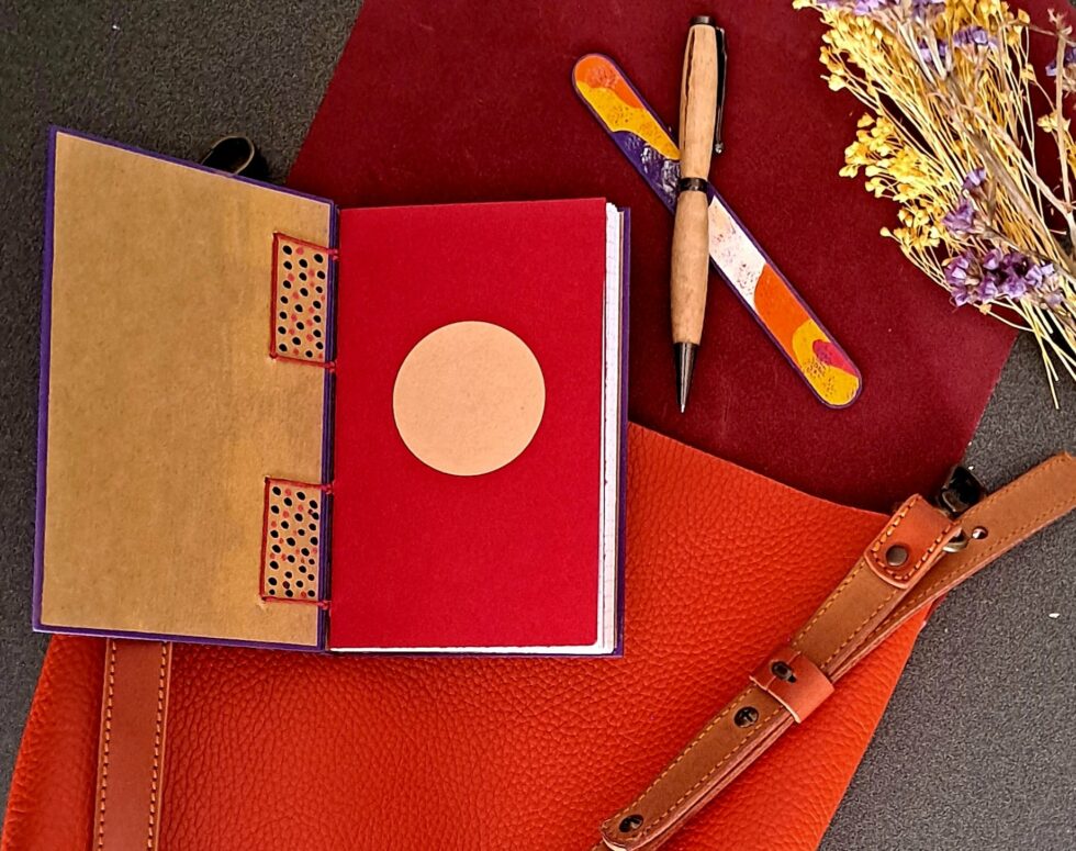 Carnet PASTORAL vue intérieure couverture et première page avec stylo en bois et marque page en bois peint.