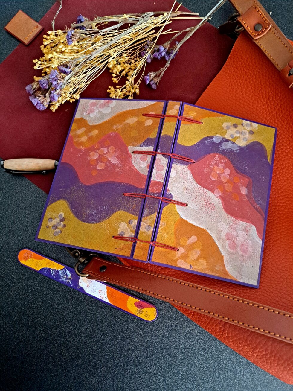 Carnet PASTORAL vue ouvert recto verso à plat avec stylo en bois et marque page en bois peint.