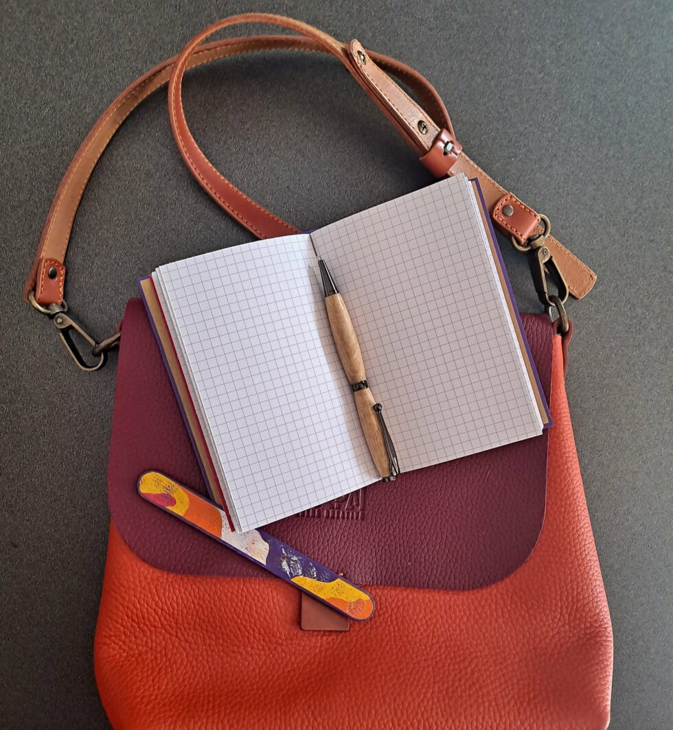 Carnet PASTORAL vue ouvert sur pages intérieures à plat avec stylo en bois et marque page en bois peint.