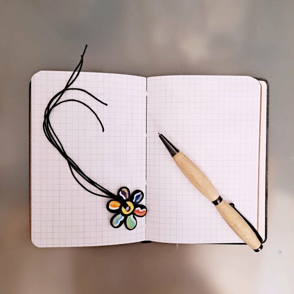 Carnet FLEUR, vue intérieur sur pages avec couverture en bois peint avec marque-pages en bois peint et stylo.