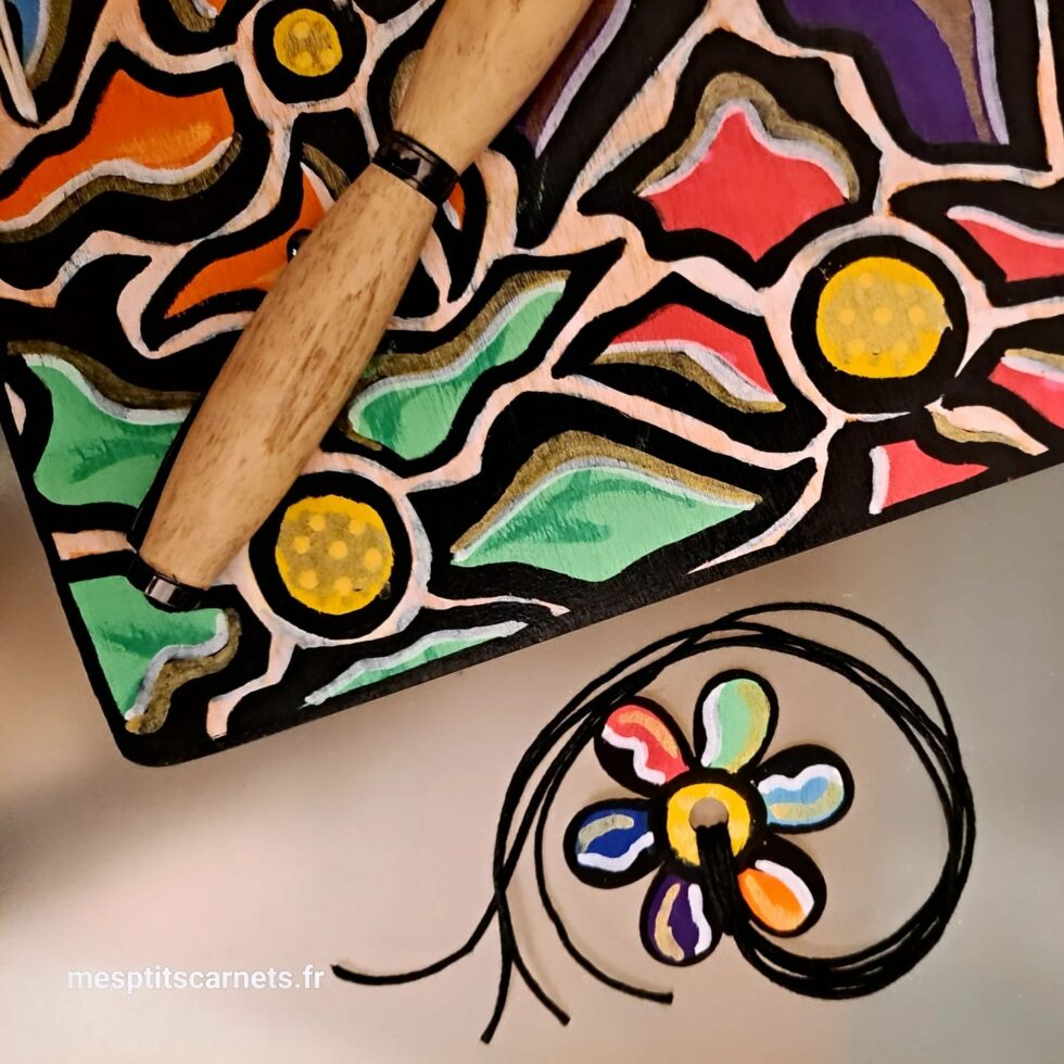 Carnet FLEUR, vue détail sur couverture avec marque-pages en bois peint et stylo.