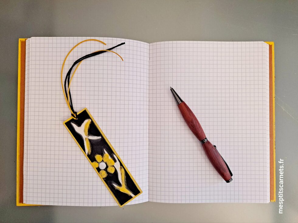 Carnet MIEL, vue couverture ouverte sur pages avec marque-pages en bois peint à la main et stylo.