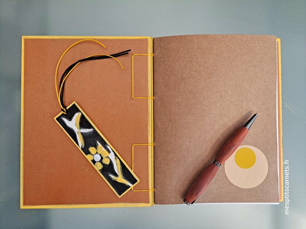 Carnet MIEL, vue couverture ouverte sur page de garde à plat avec marque-pages en bois peint à la main et stylo.