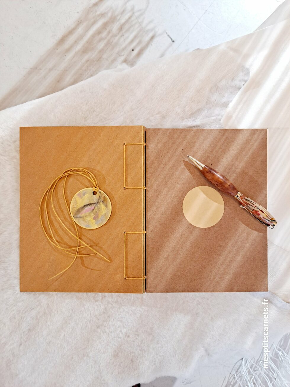 Carnet FLAMMES, vue intérieure à plat avec couverture en bois peint et page de garde avec marque-pages en bois peint et stylo.