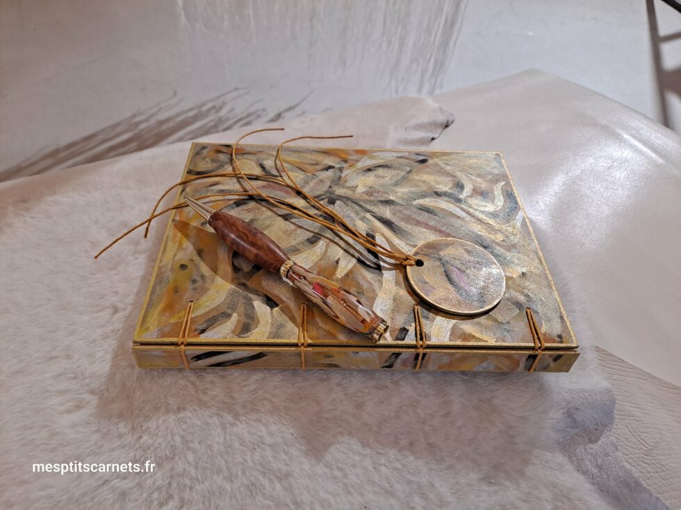 Carnet FLAMMES, vue recto et dos à plat avec couverture en bois peint avec marque-pages en bois peint et stylo.