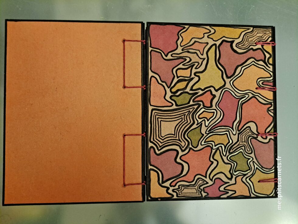 Carnet Triptyque SILICE vue semi ouvert de face panneau fermé et couverture en bois peint et stylo.