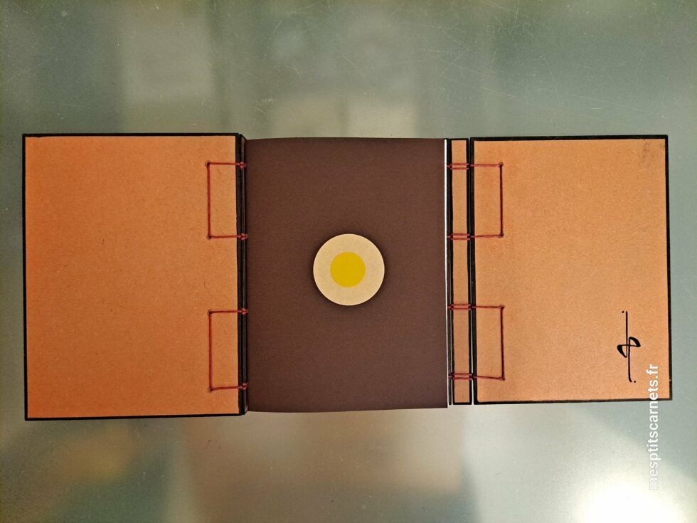 Carnet Triptyque SILICE vue ouvert de face sur page de garde et couverture en bois peint et stylo.