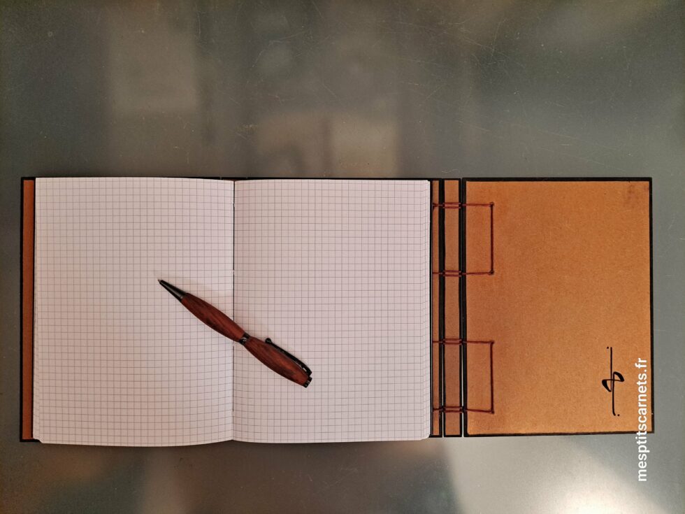 Carnet Triptyque SILICE vue ouvert de face sur pages et couverture en bois peint et stylo.