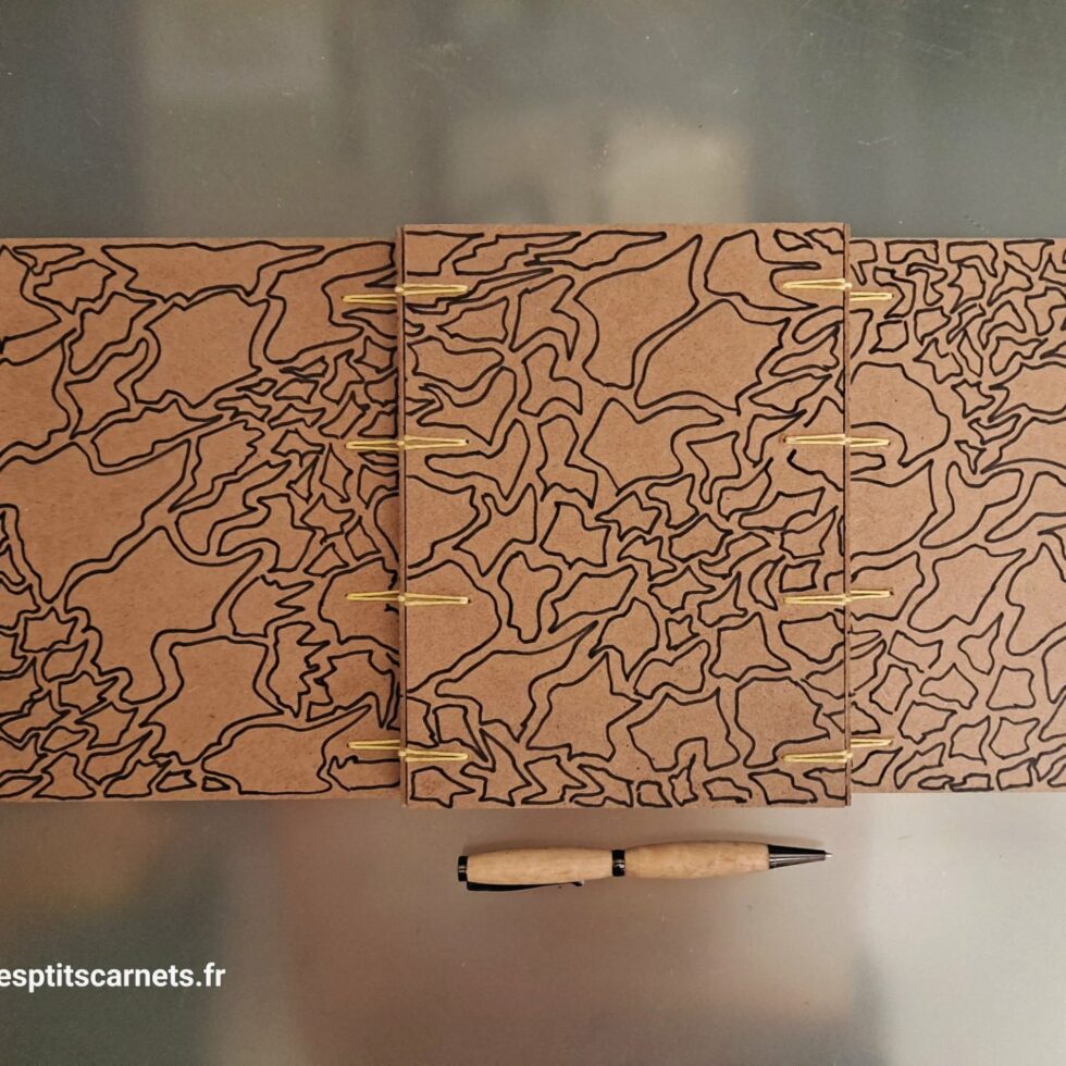 Carnet Triptyque OUED vue ouvert de dos et couverture en bois peint et stylo.