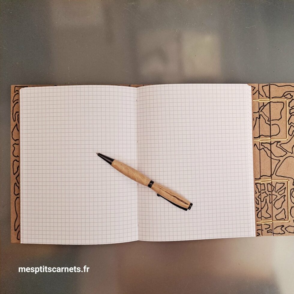 Carnet Triptyque OUED vue ouvert de face sur pages et couverture en bois peint et stylo.