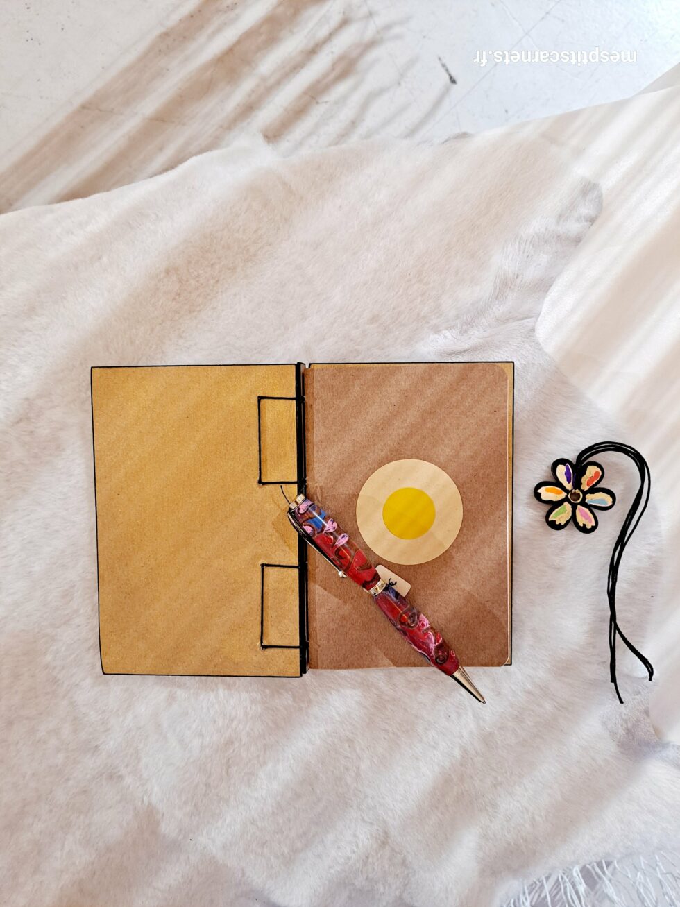 Carnet MAG, vue intérieure sur pages et couverture avec marque-pages en bois peint et stylo.