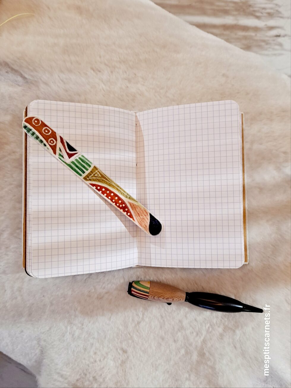 Carnet PHARE, vue intérieur sur pages petits carreaux et couverture avec marque-pages en bois peint. à plat et couverture avec marque-pages en bois peint et stylo.