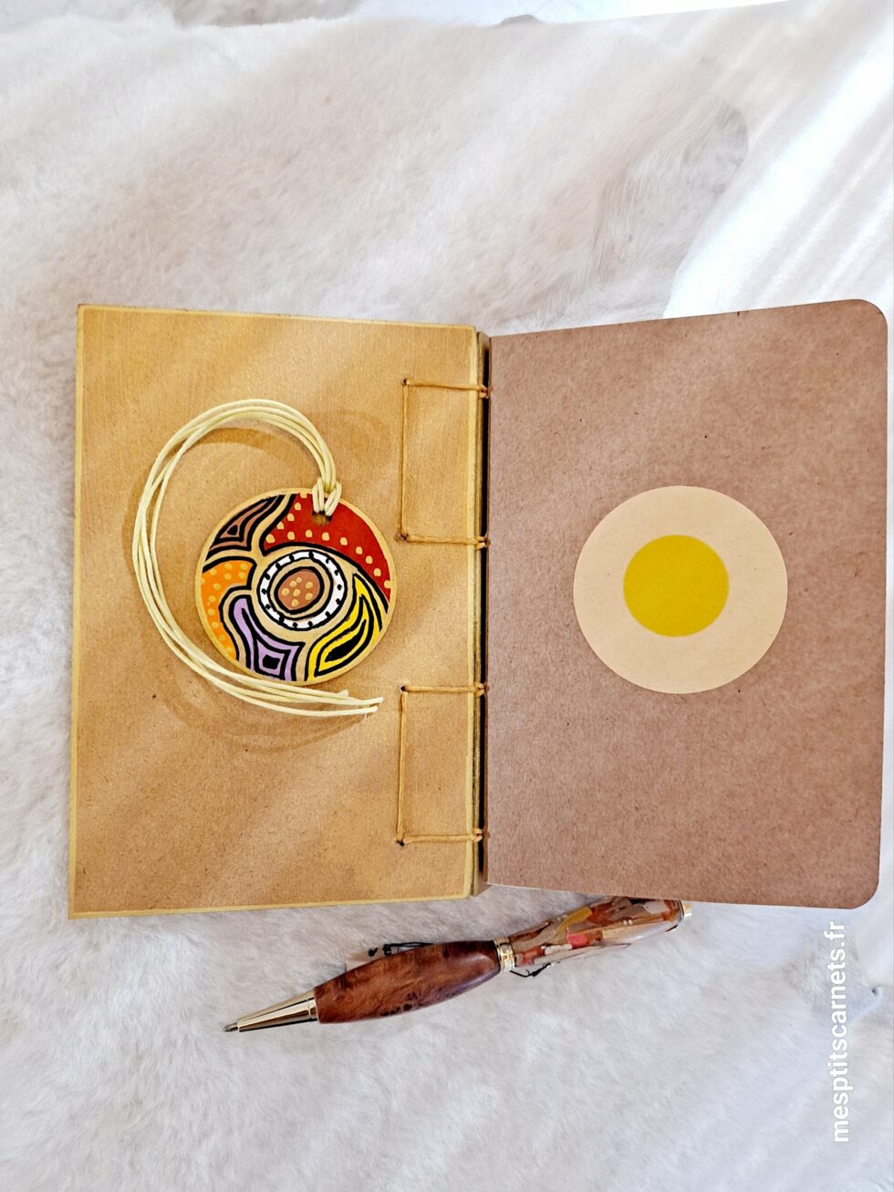 Carnet AUSTRIA, vue intérieur sur pages à plat et couverture avec marque-pages en bois peint et stylo.