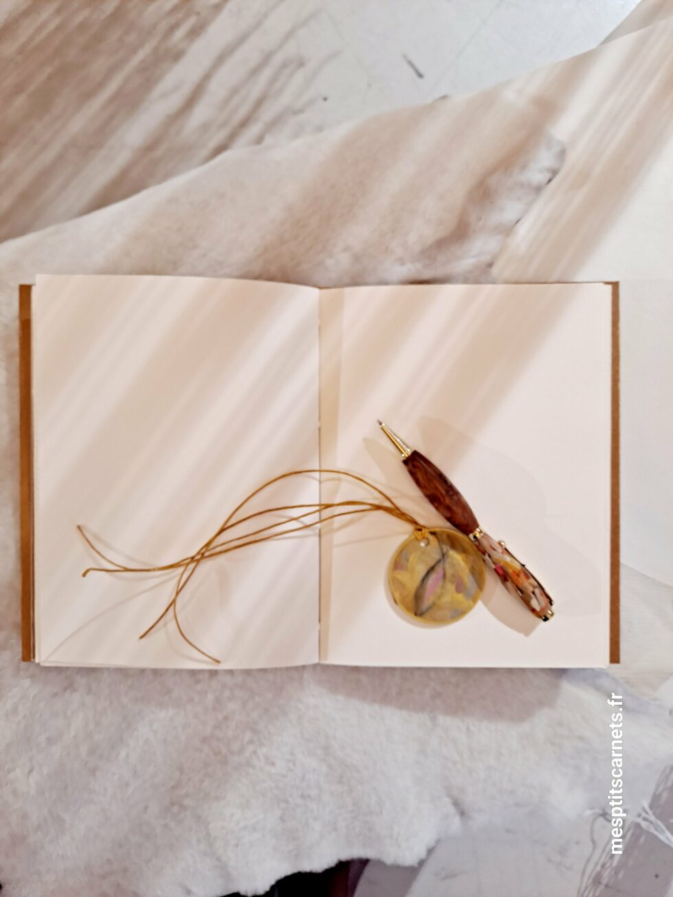 Carnet FLAMMES, vue intérieure sur pages avec marque-pages en bois peint et stylo.