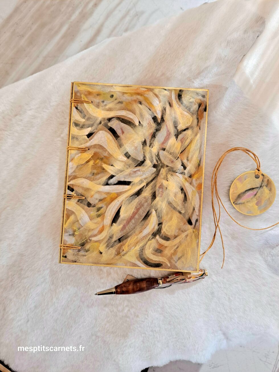 Carnet FLAMMES, vue recto à plat avec couverture en bois peint avec marque-pages en bois peint et stylo.