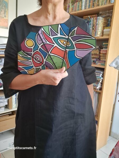 Eventail COSMOS en bois peint à la main, vue recto face ouvert à plat en action à la main, pour le format.